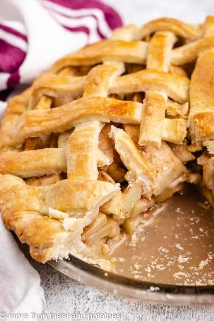 The whole pie in a pan missing one slice.