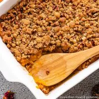 Baked sweet potato casserole with pecan streusel in a dish.