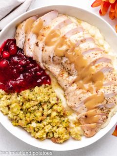 An aerial view of sliced turkey breast with sides.