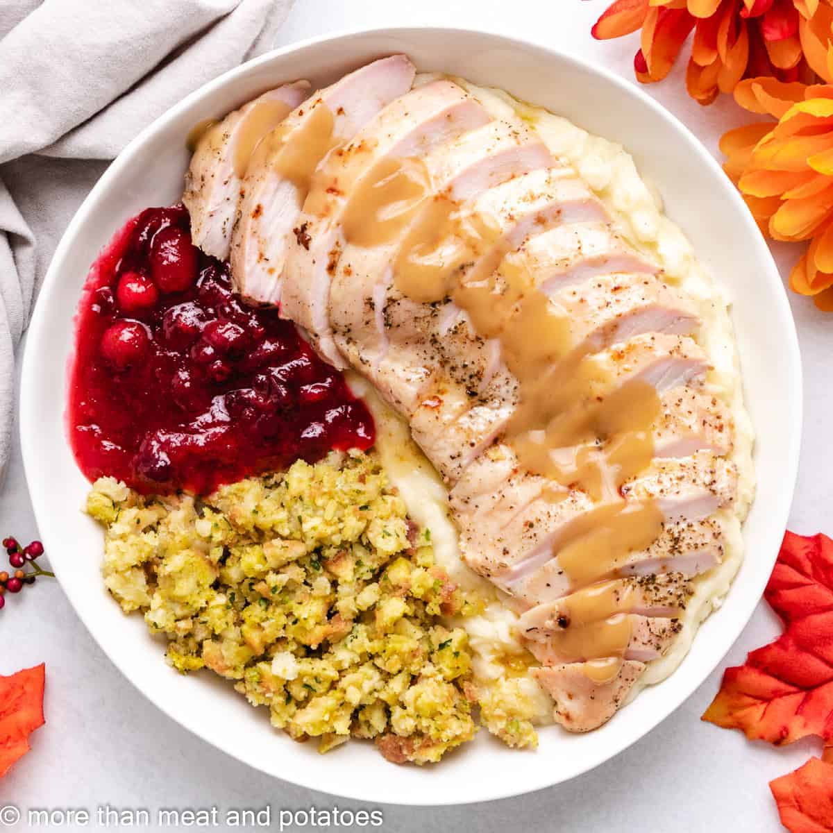 An aerial view of sliced turkey breast with sides.