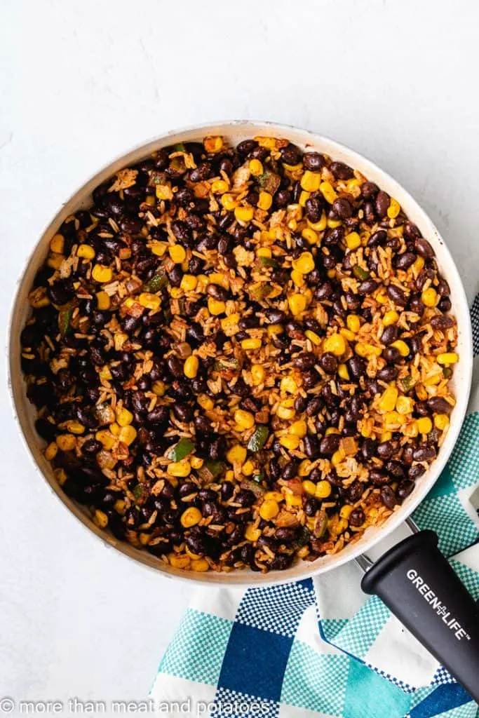 Black beans, corn, and other ingredients added to the skillet.
