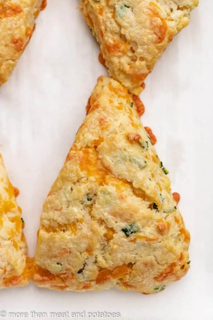 A close-up of a fresh baked scones on a sheet pan.