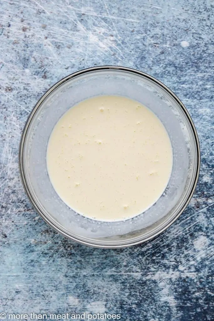 Heavy cream and an egg combined in a mixing bowl.