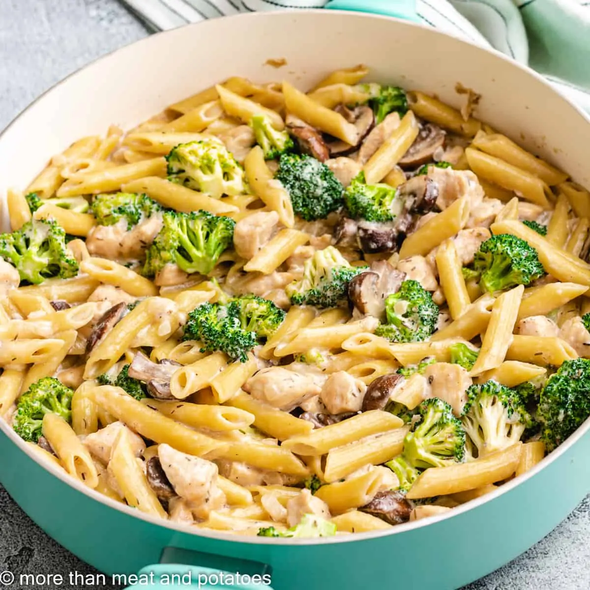 The finished chicken mushroom broccoli pasta in a skillet.