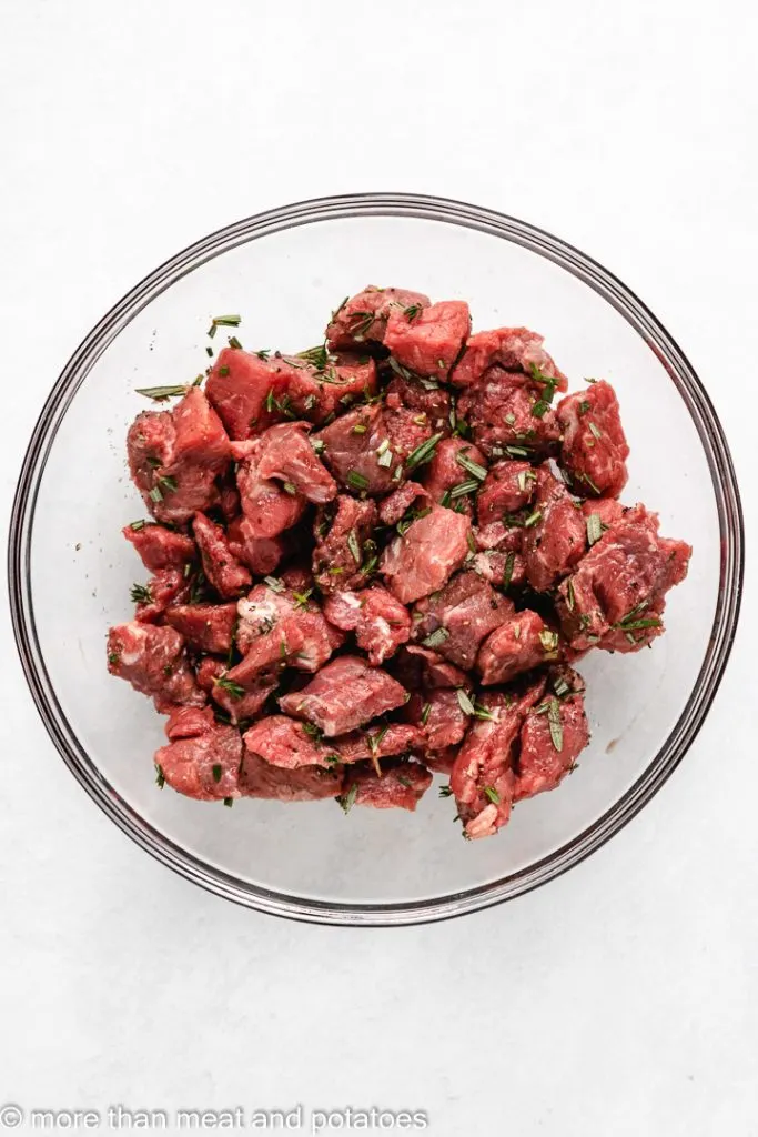 Stew meat and spices tossed together in a bowl.