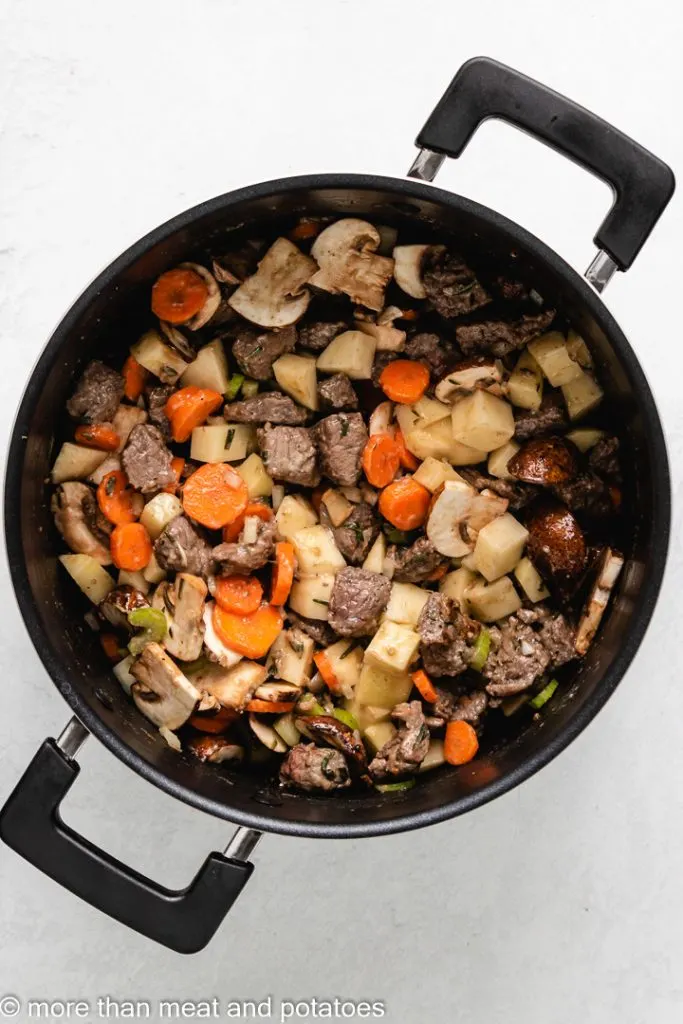 Potatoes, carrots, and other vegetables added to the pot.