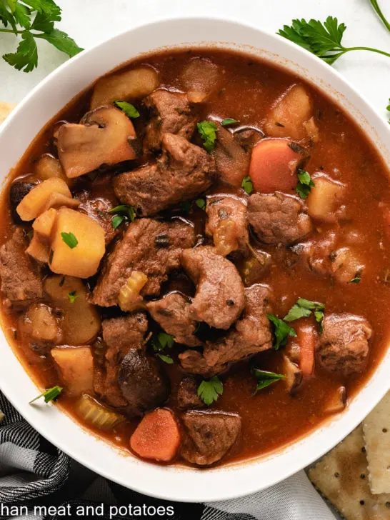 An aerial view of the stove-top beef stew with crackers.