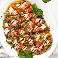 Top down of caprese flatbread on a plate.