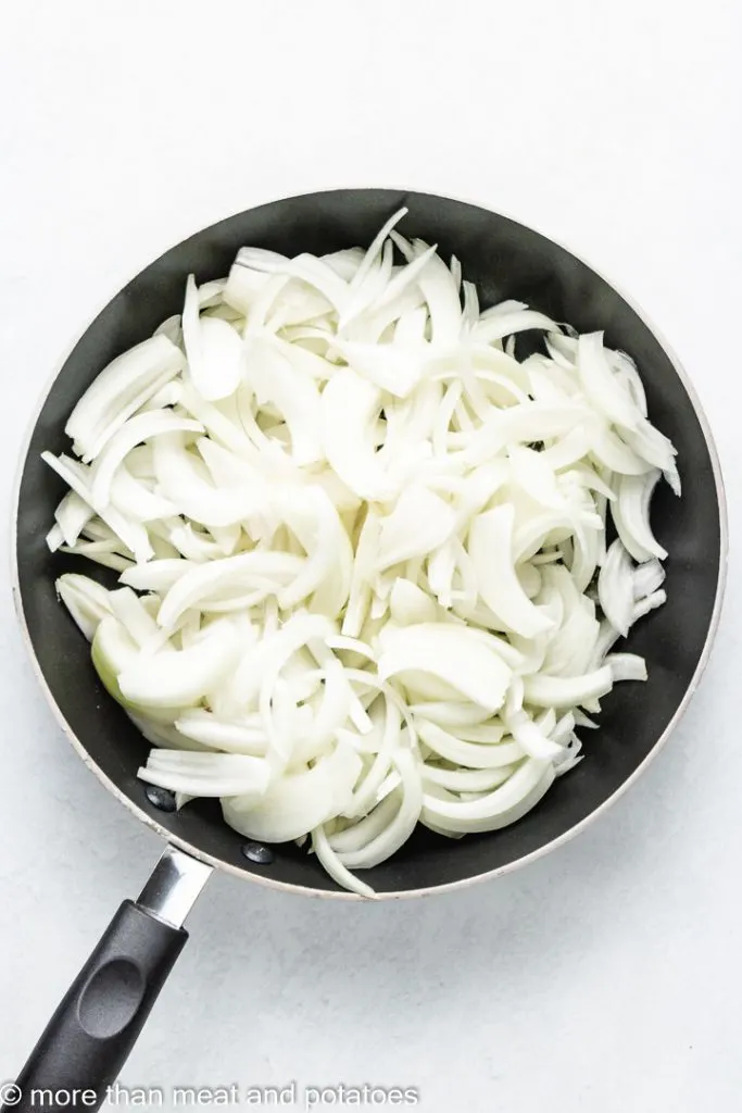 Olive oil and sliced onions in a sauté pan.