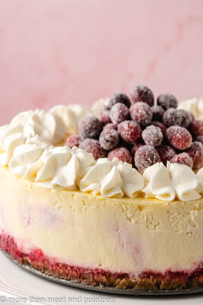 Cheesecake with cranberries and whipped cream.