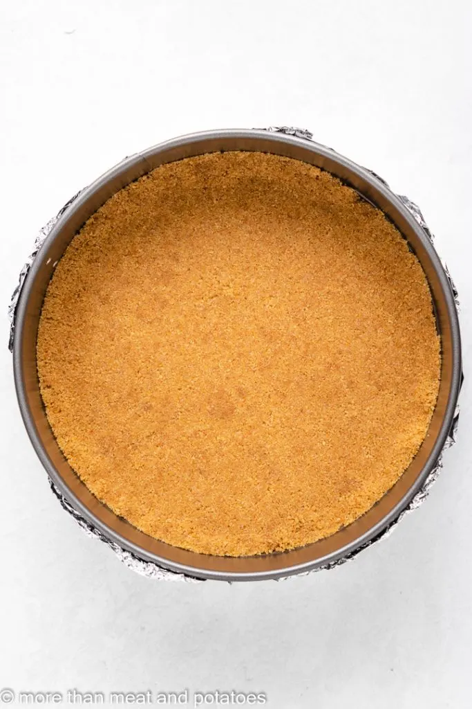 Graham cracker crust in a springform pan.