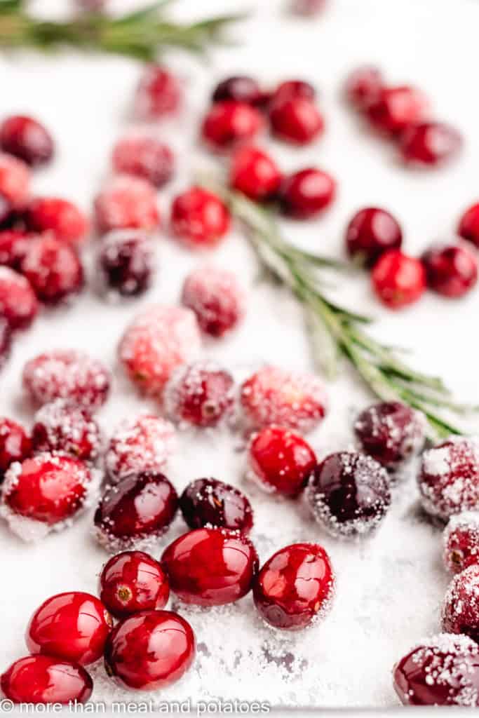 The herbs and berries being coated in granulated sugar.