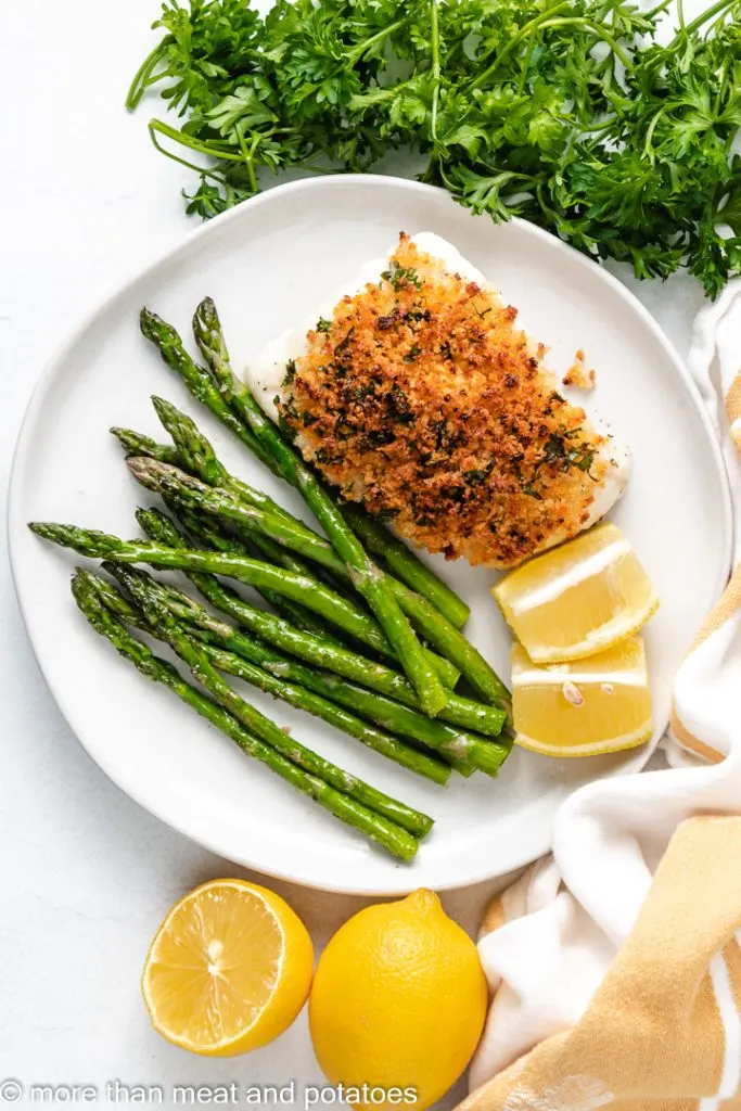 Top down view of baked cod with panko on a plate.