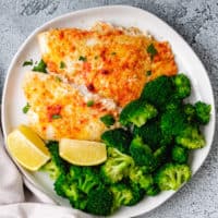 Top down view of flounder with lemon and broccoli.