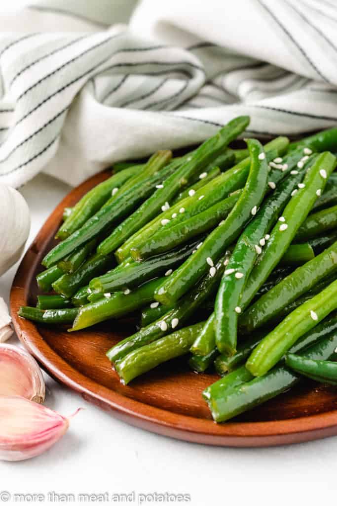 Honey garlic green beans on a brown plate.