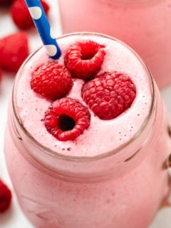 Top down shot of fresh berries on top of a Raspberry Smoothie.