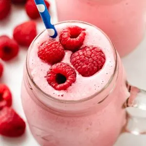 Top down shot of fresh berries on top of a raspberry smoothie.