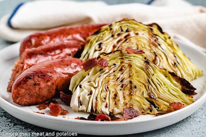 Roasted cabbage wedges with balsamic and bacon on a plate.