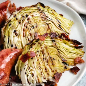 Two cabbage wedges with crumbled bacon and sausage.