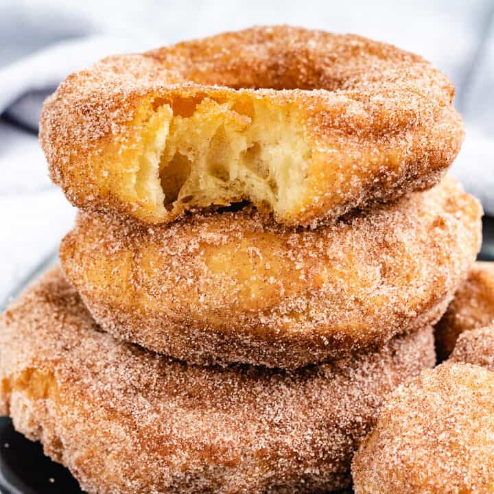 Cinnamon sugar doughnuts with a bite taken out.