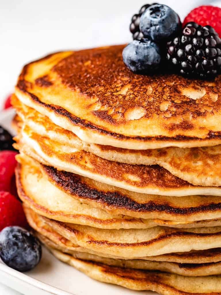 Stack of sourdough starter pancakes with fresh berries.