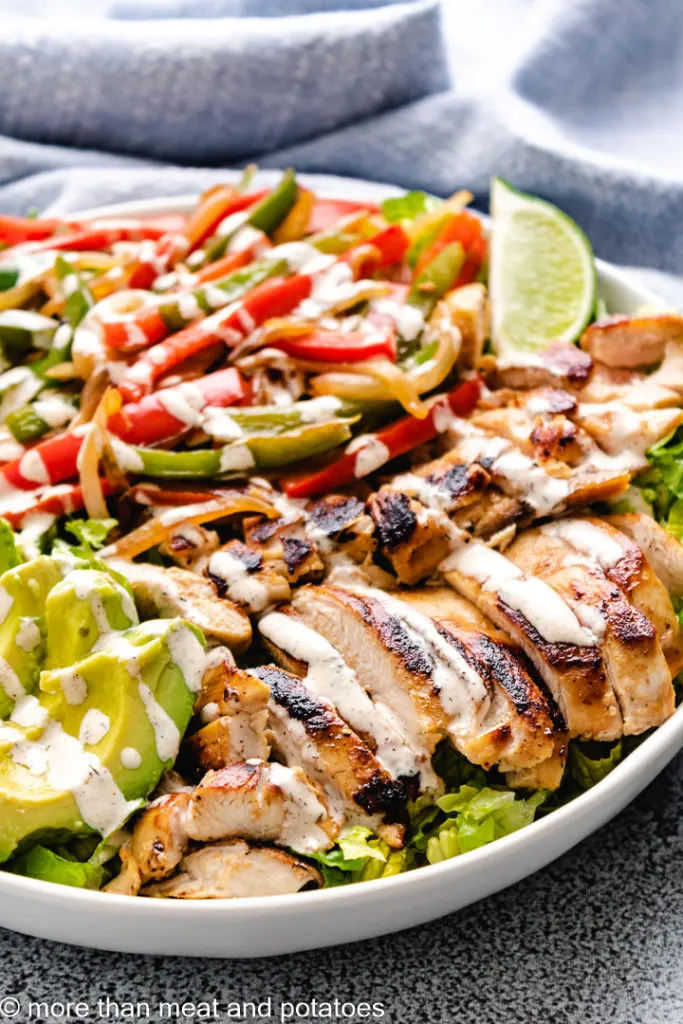 Chicken fajita salad with peppers and onions.