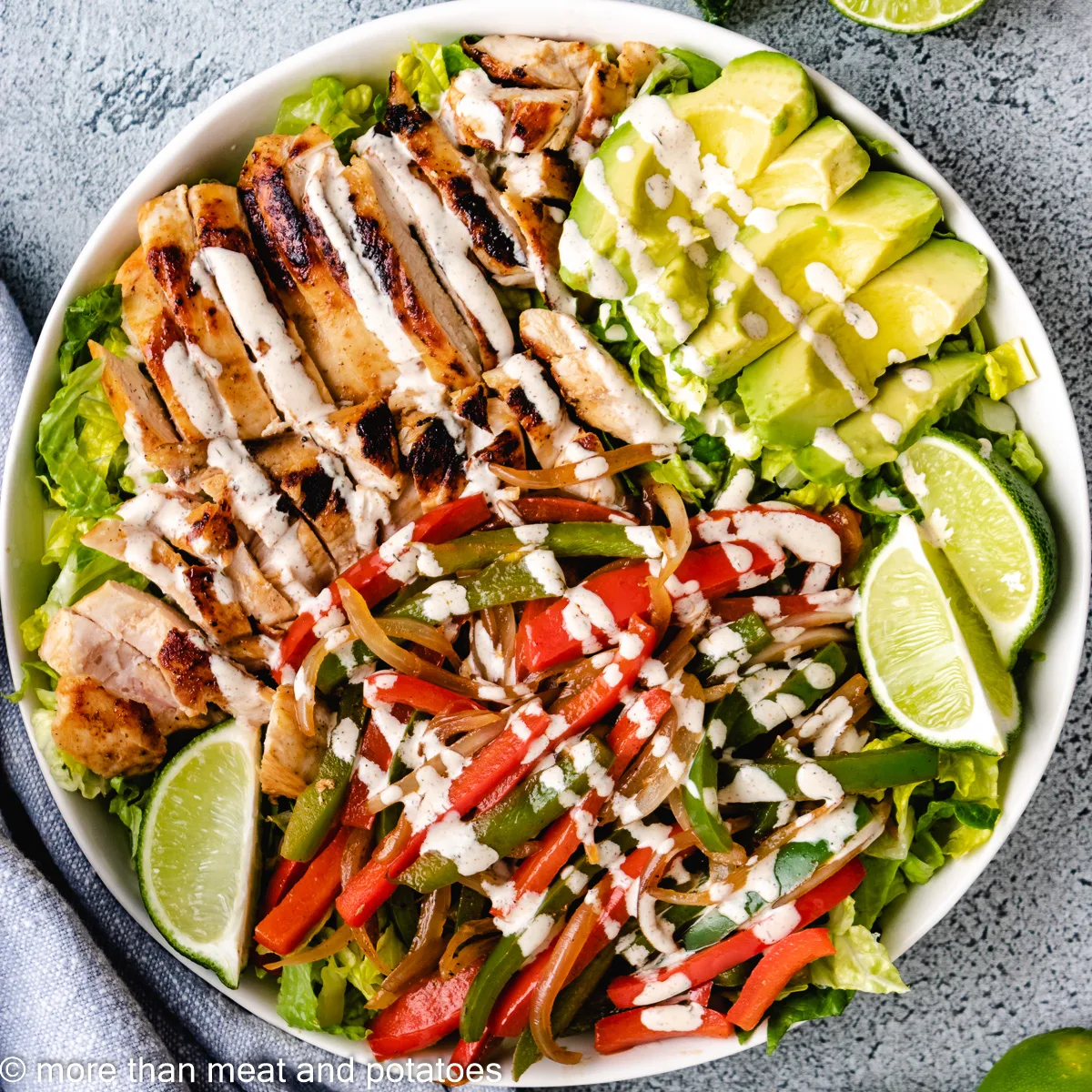 Top down view of chicken fajita salad with avocado slices.