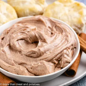 Cinnamon butter in a bowl and cinnamon sticks.