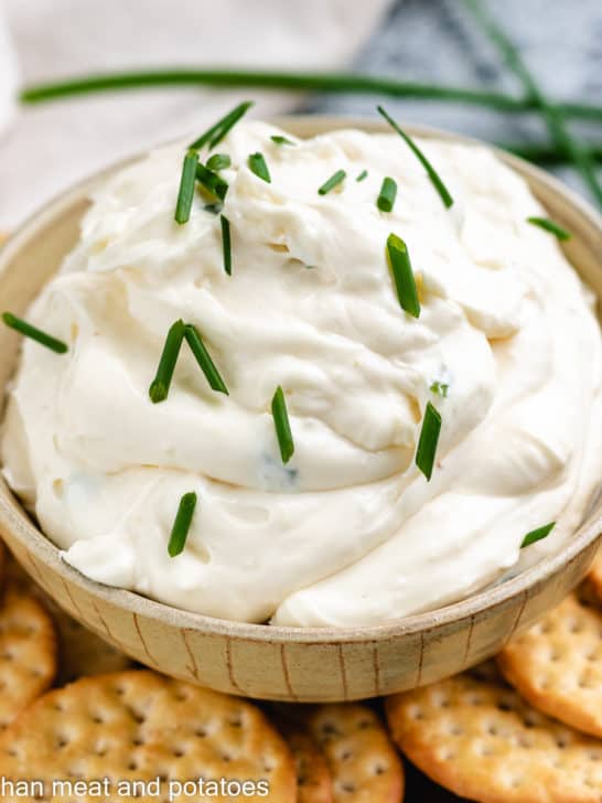 Garlic dip with crackers and fresh chives.
