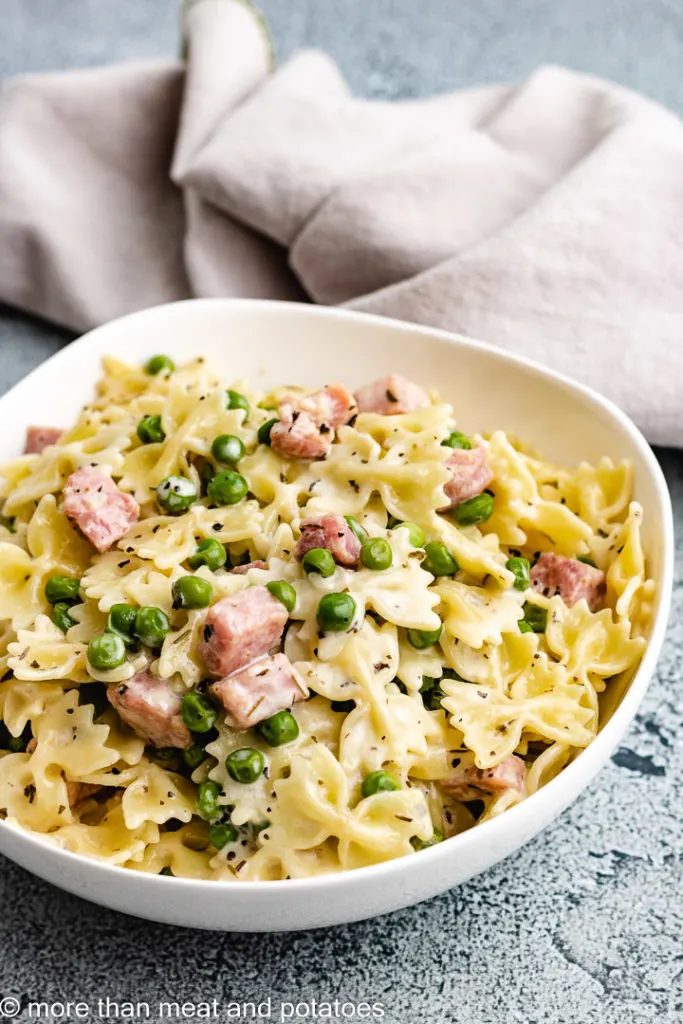 Bowl of pasta with peas and ham.