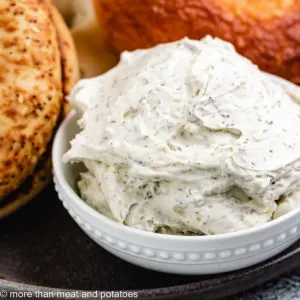 Garlic herb cream cheese in a small, white dish.