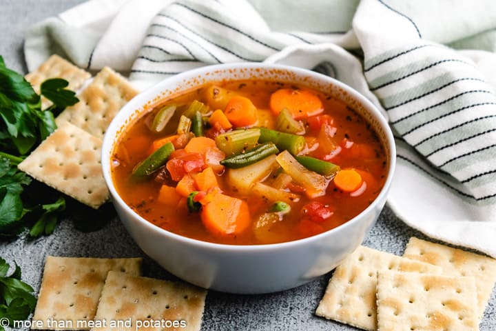 Homemade vegetable soup with frozen vegetables in a blue bowl.