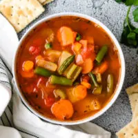 Top down view of vegetable soup with crackers.