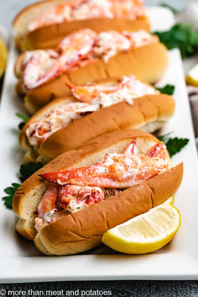 Lobster rolls on a white platter.
