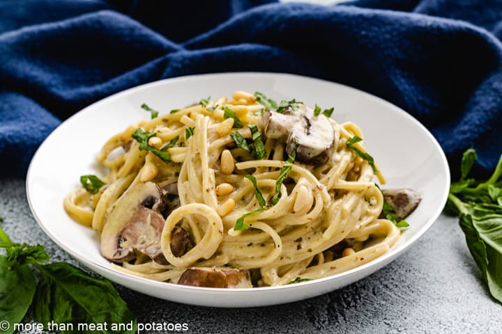 Mushroom pesto pasta on a white plaste.