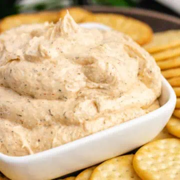 Square white bowl filled with ranch dip.