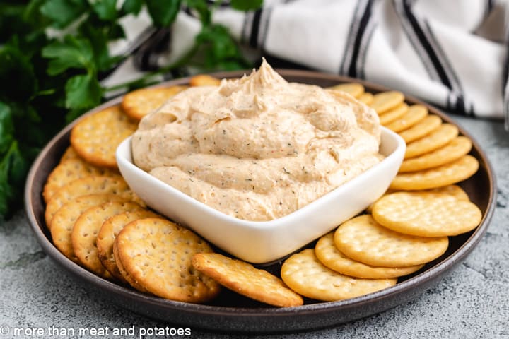 Ranch dip in a square dish with crackers.