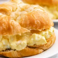 Close up photo of egg salad on a croissant.