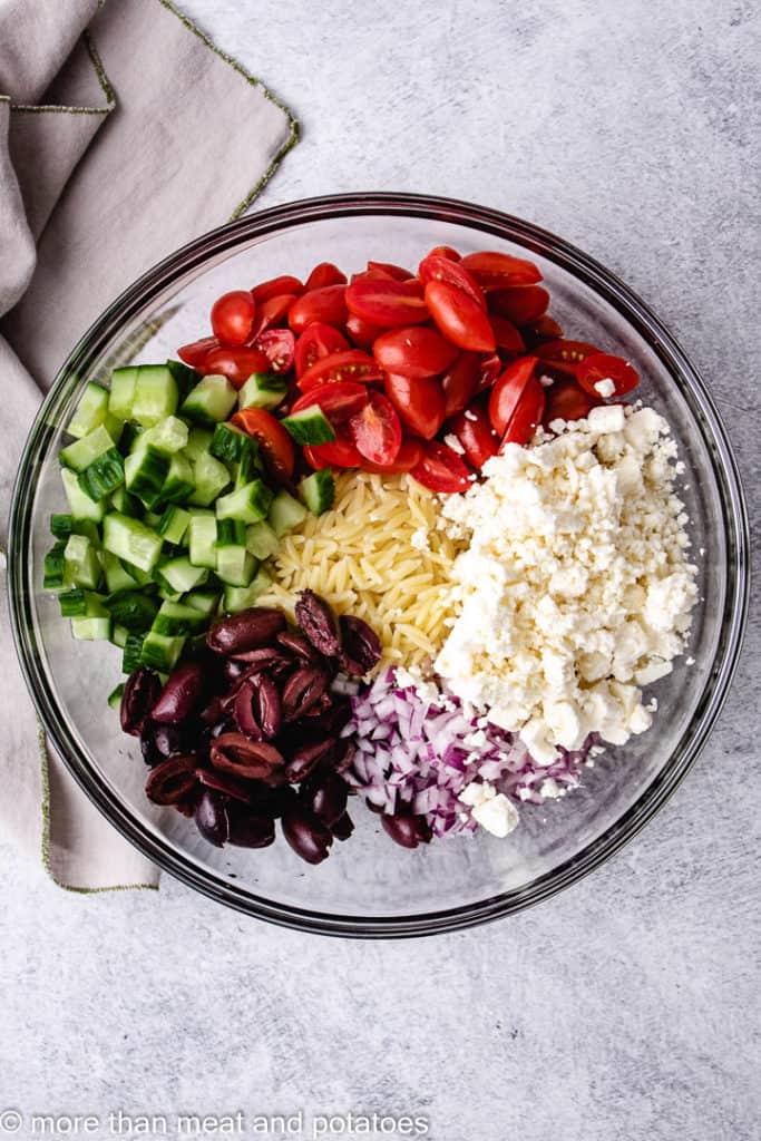 Top down view of the ingredients for greek orzo salad.