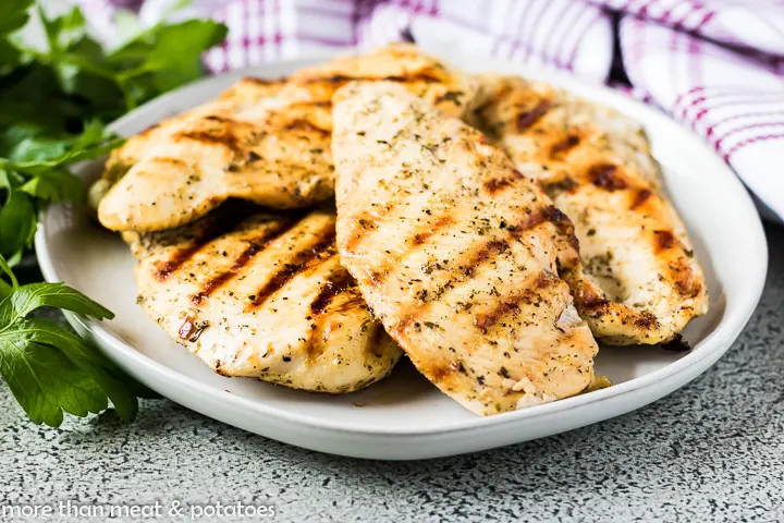 The grilled chicken flavored with an italian marinade on a plate.