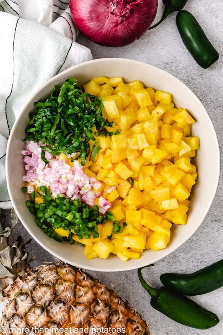 Ingredients for mango pineapple salsa unmixed in a bowl.