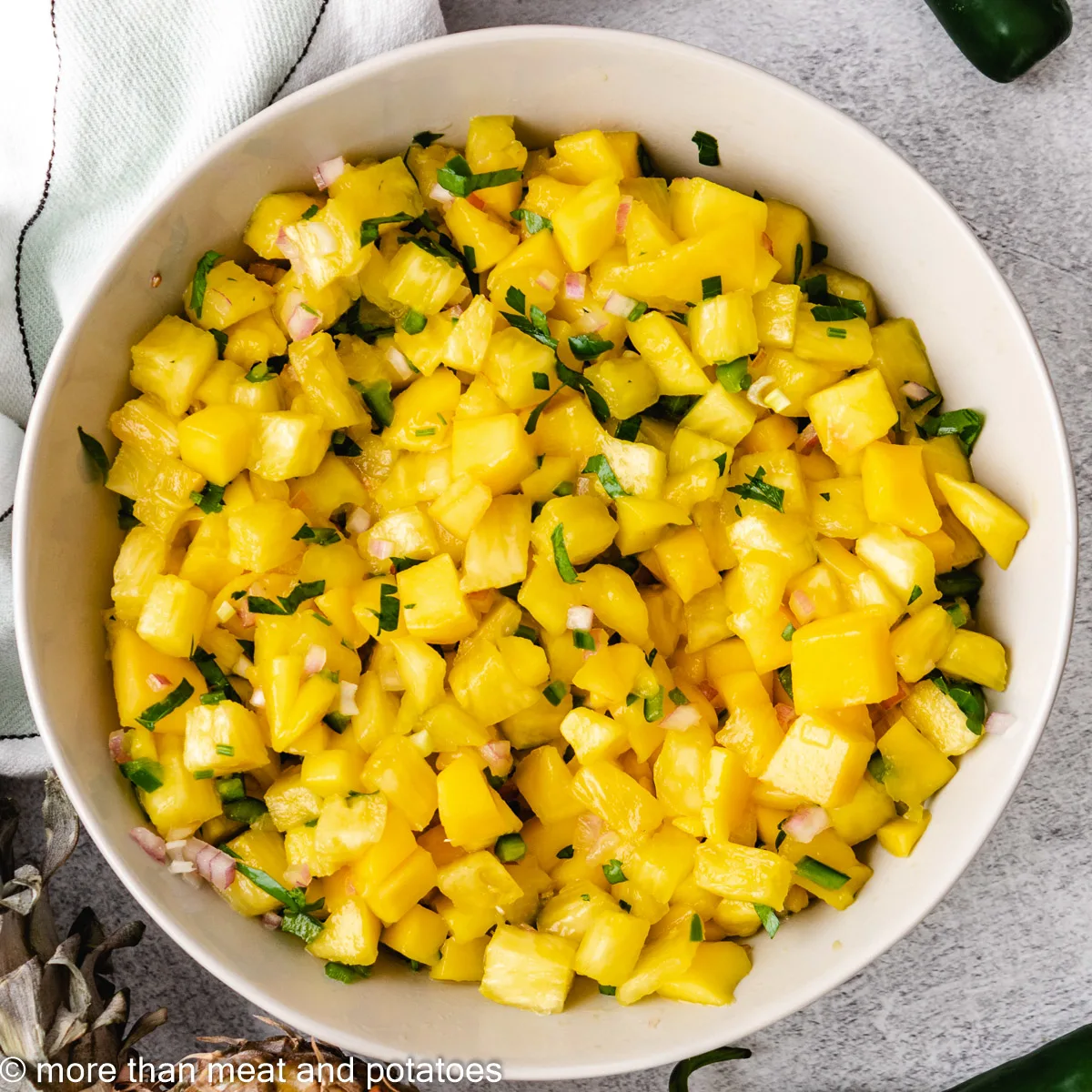 Top down view of fruit salsa with cilantro and lime juice.