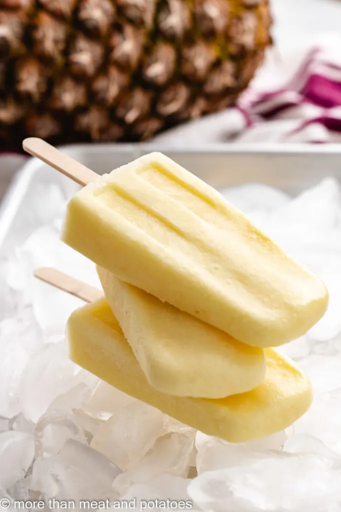 Stacks of pineapple popsicle on ice.