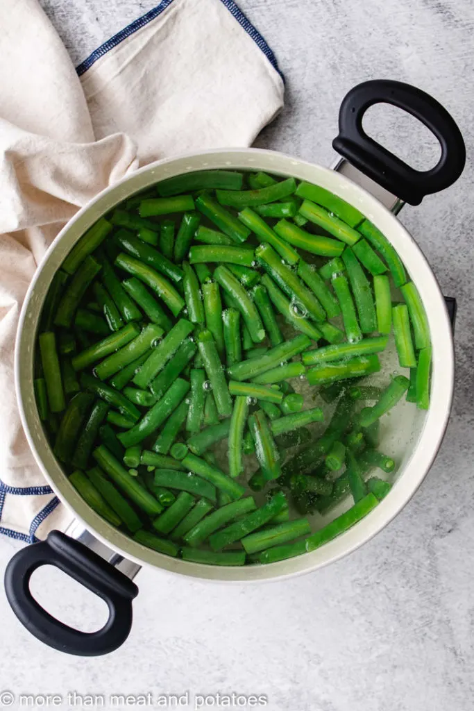Green beans in water in a pan.