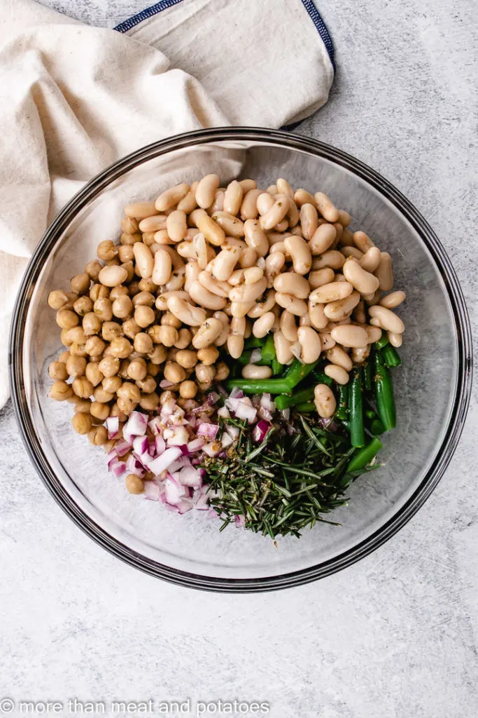 Bean salad topped with dressing in a glass bowl.