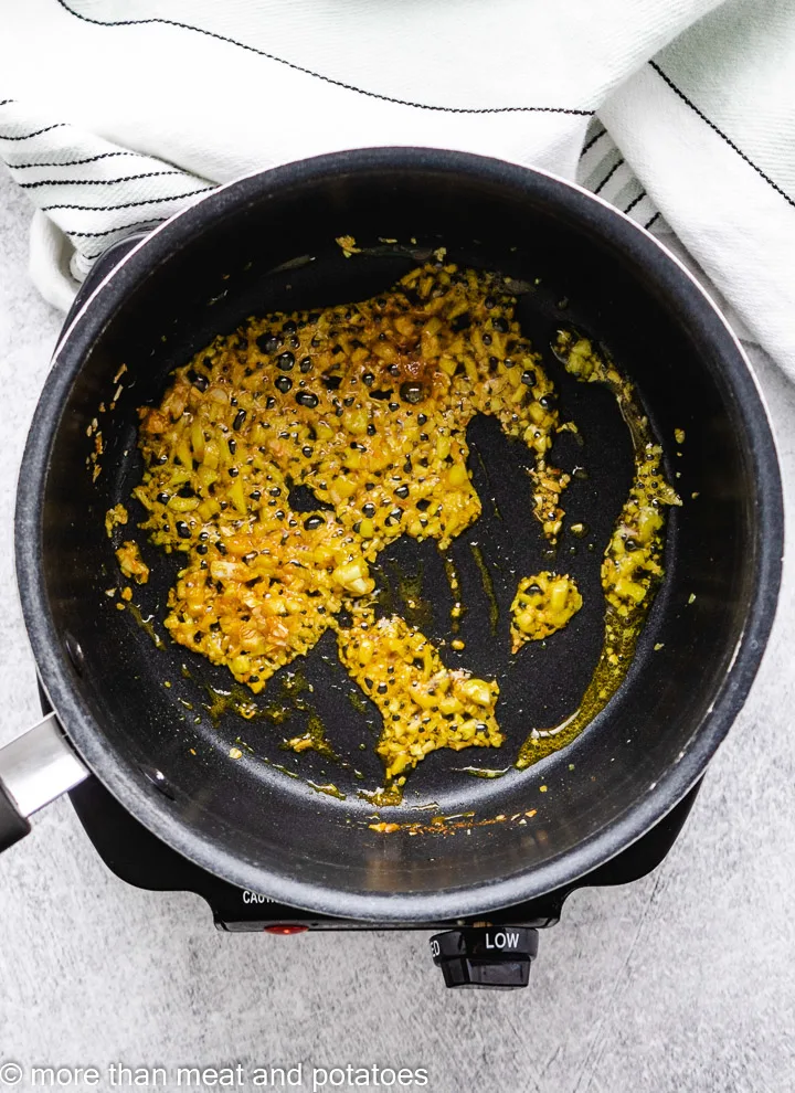 Garlic, minced onion, and spices in a saucepan.