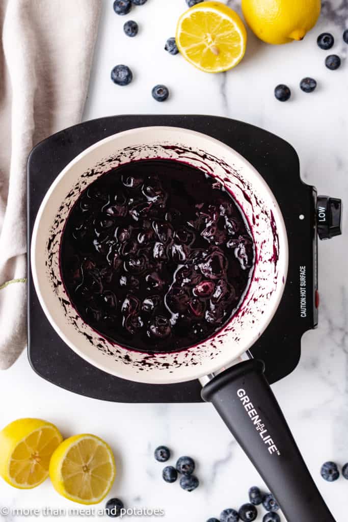 Top down view of cooked blueberries in a pan.