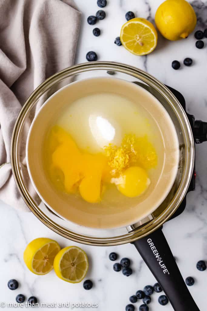 Top down view of ingredients for lemon curd in a double boiler.