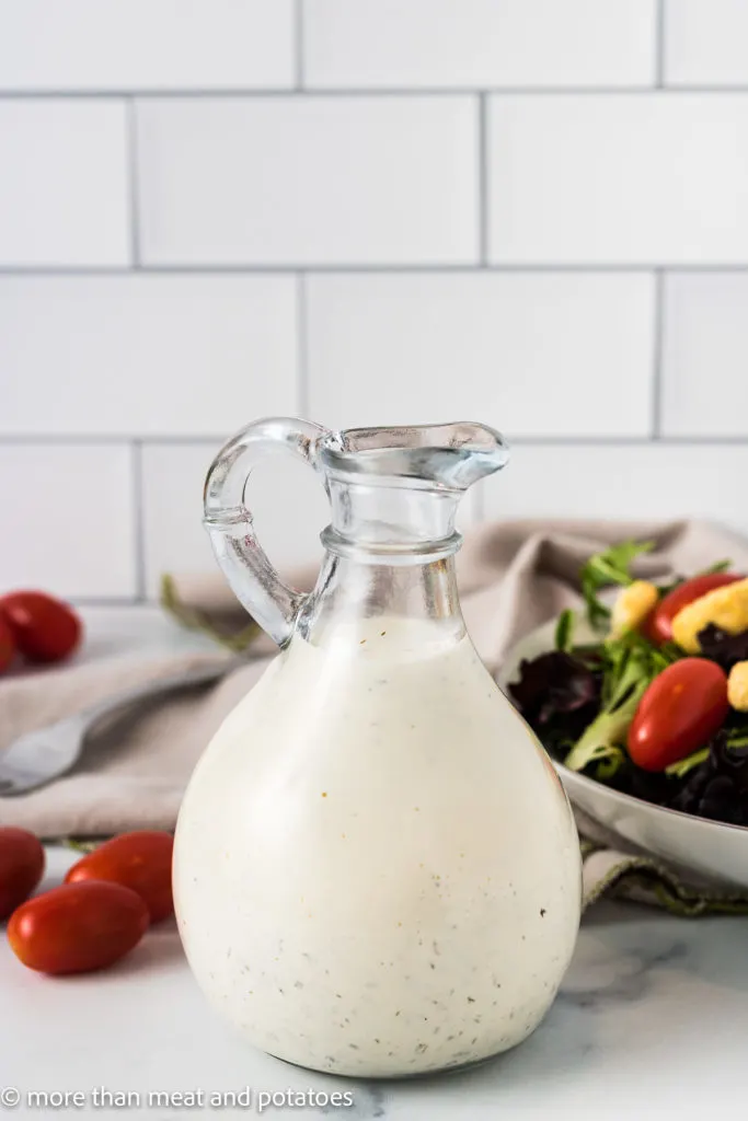 Jar of ranch dressing with a salad.