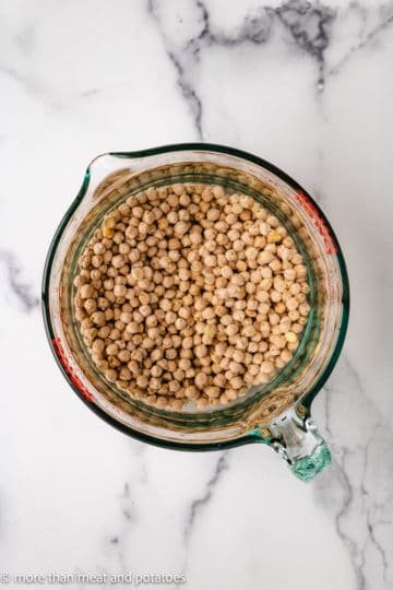 Top down view of chickpeas in water.